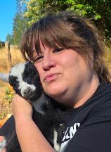 Logston holding a black and white baby goat