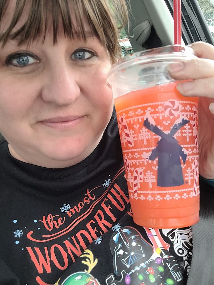 Logston holding a big orange drink in a holiday cup