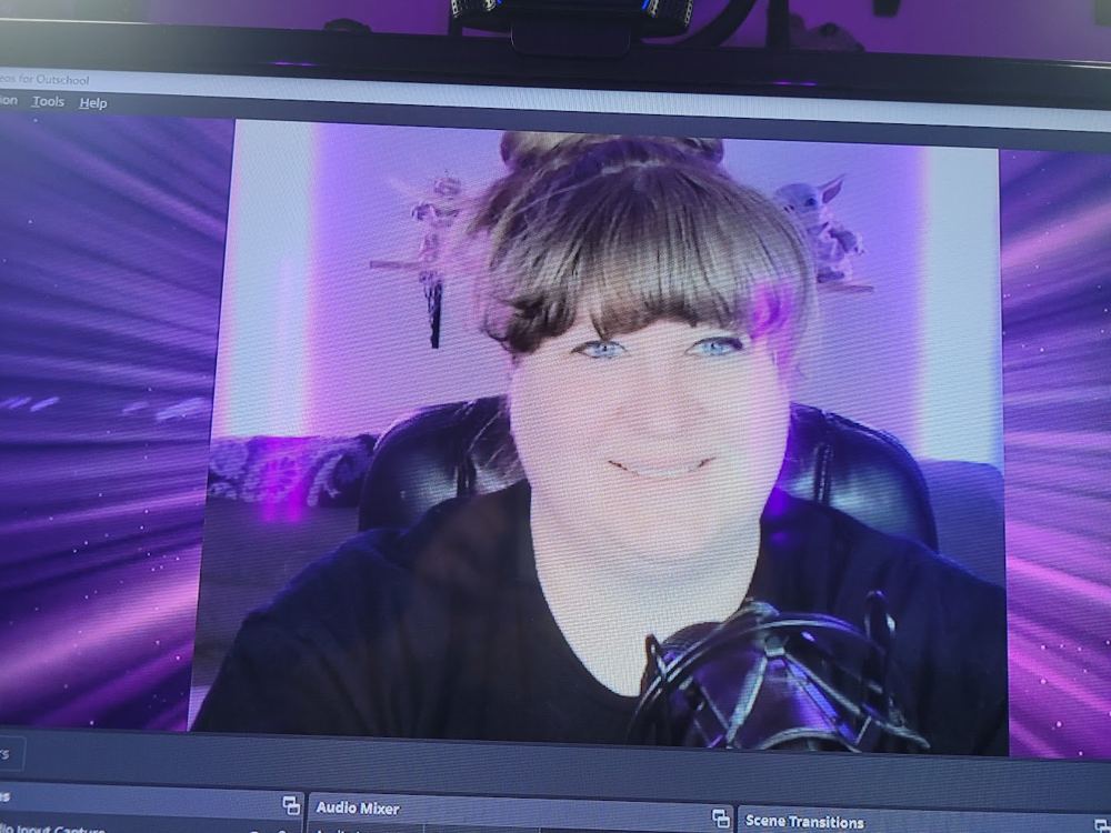 Logston on a computer screen in her purple-lit online teaching setup