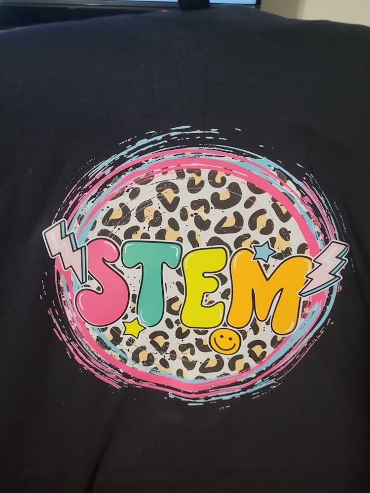 A black T-shirt with colorful STEM letters on a leopard-print circle